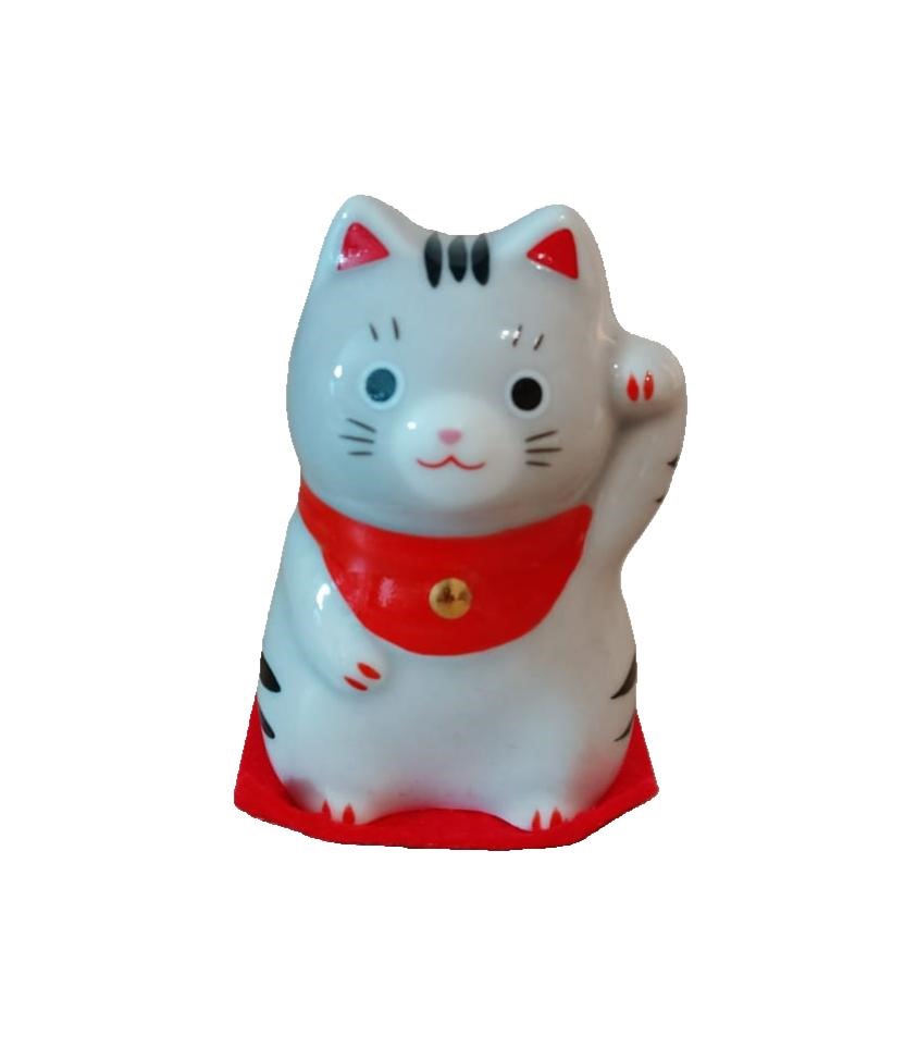 Gatto giapponese, Maneki Neko, letteralmente "gatto che chiama" ,tipico  porta fortuna, spesso utilizzato anche nelle attività commerciali per attirare clienti, fortuna e denaro, in base alla zampa che tiene alzata. Piccolo gattino della fortuna calico, tricolore bianco nero e rosso, che siede sopra ad un tappetino rosso, con un bavaglino al collo di colore sempre rosso con una campanellina color oro.